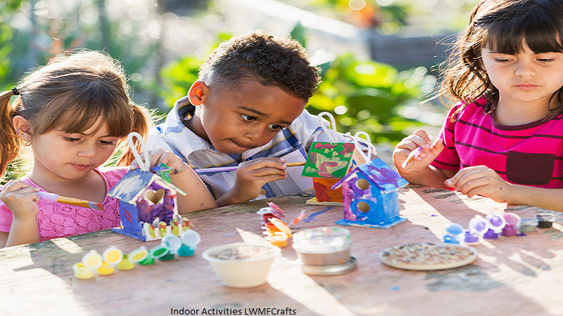 Children enjoying indoor activities lwmfcrafts by painting and decorating handmade craft houses.